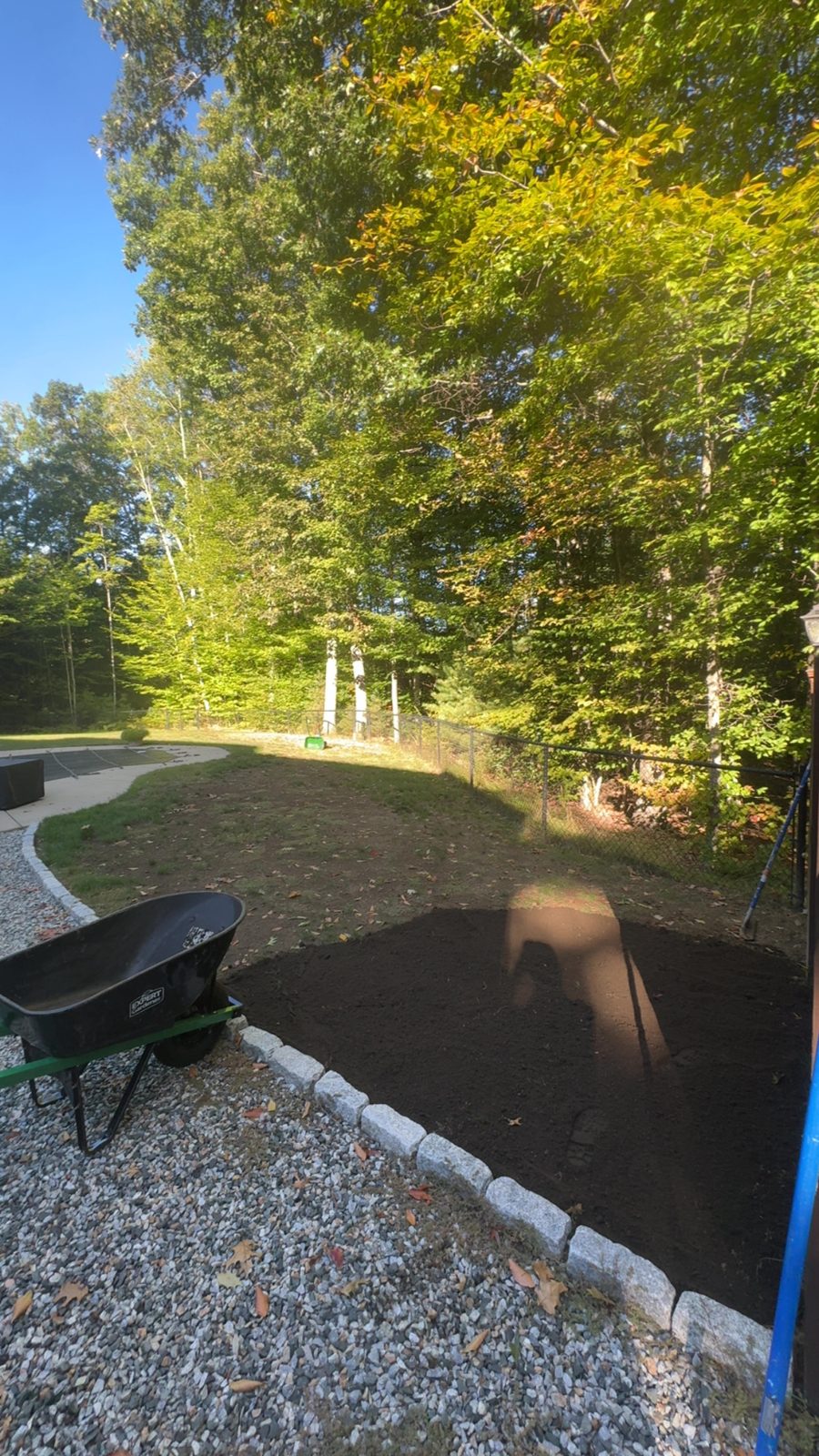 Fresh mulch bed edged with stone beside a gravel area