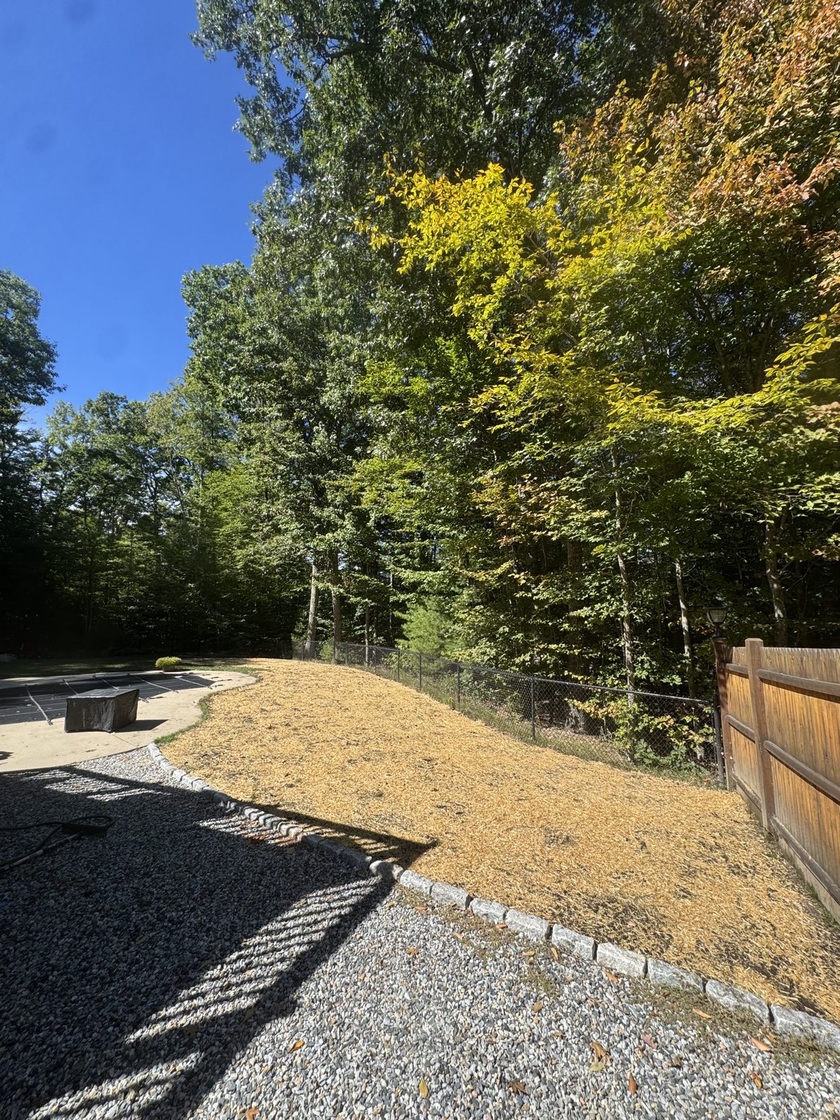 Gravel sitting area with stone edging below a seeded slope