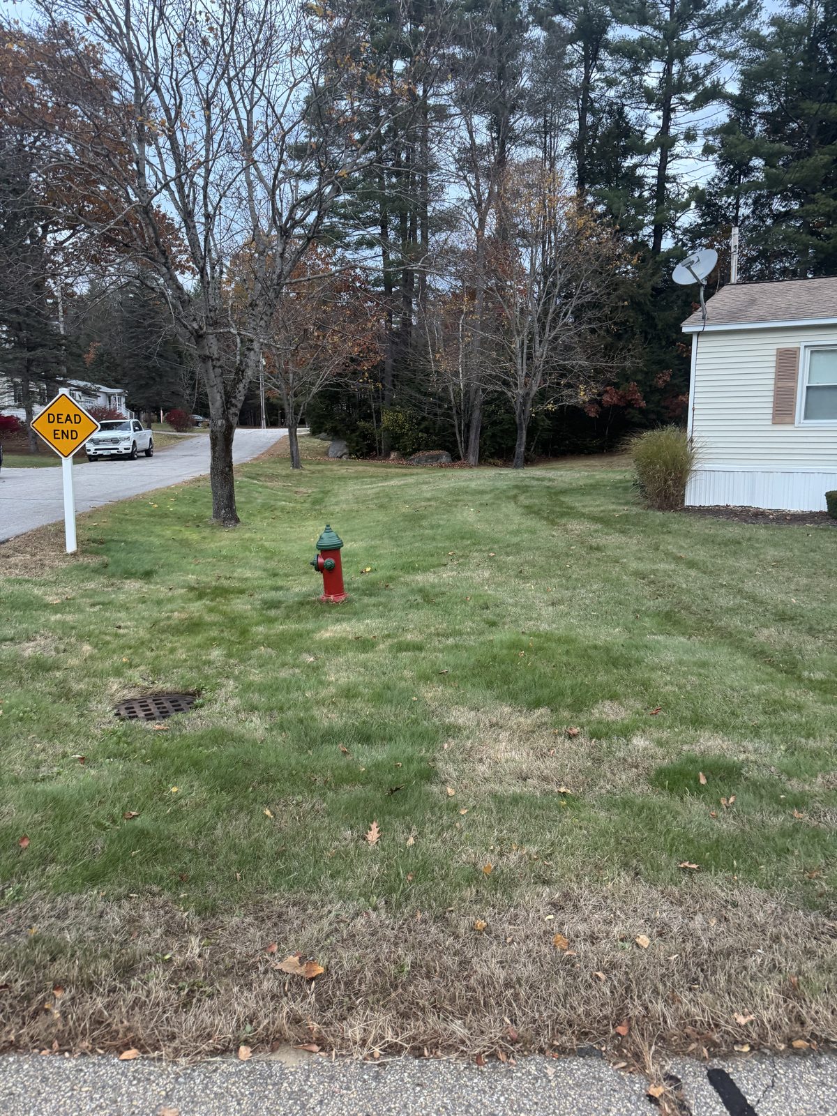 Freshly mowed striped lawn with edged mulch beds in front of a New England home