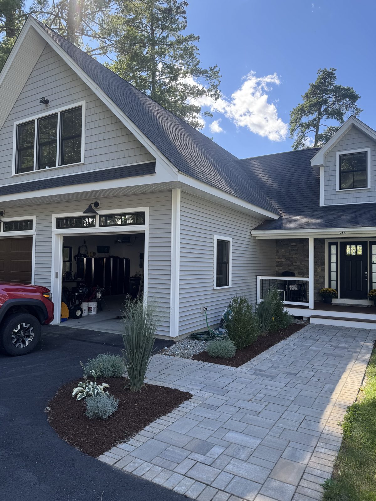 New paver walkway and planted beds leading to a front door