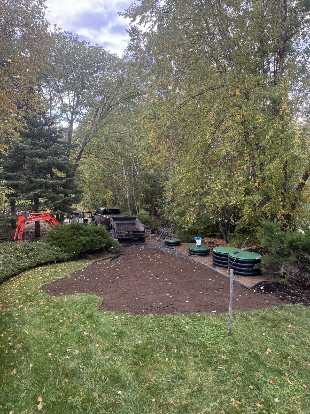 Graded soil ready for sod beside a septic install